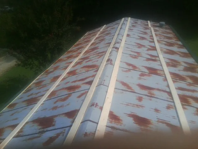 Rusted metal roof panels with new wood purlins before replacement — Storm Damage Roof Repair in Geneva by Roofing Brothers